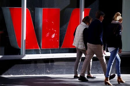 Pedestrians walk past a logo of the Westpac Bank Corp on display in a window of a branch located in central Sydney, Australia, July 2, 2016. REUTERS/David Gray