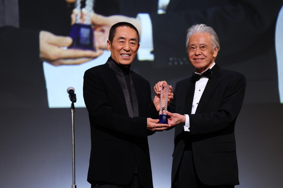 安藤裕康（右）在開幕典禮上頒發特別貢獻獎給中國導演張藝謀。（東京國際影展提供）