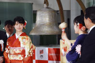 A kimono-clad employee of the Tokyo Stock Exchange tolls a bell during a ceremony marking the start of this year's trading in Tokyo Monday, Jan. 6, 2020, in Tokyo. (AP Photo/Eugene Hoshiko)