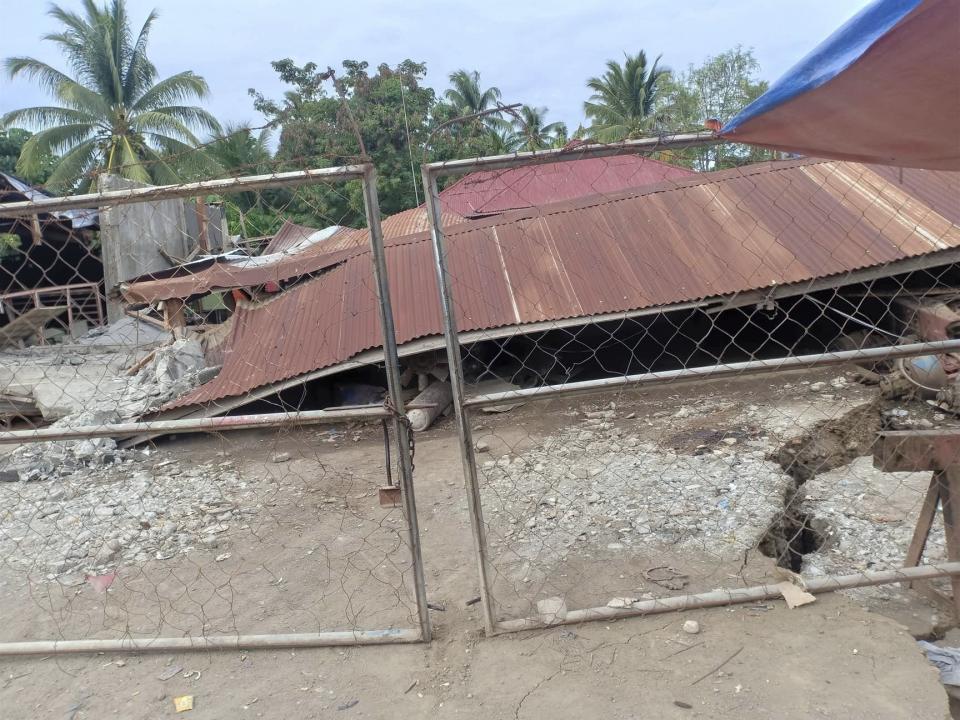 A collapsed structure lies following an earthquake that struck Davao del Sur province, southern Philippines on Sunday Dec. 15, 2019. A strong quake jolted the southern Philippines on Sunday, causing a three-story building to collapse and prompting people to rush out of shopping malls, houses and other buildings in panic, officials said. (AP Photo/John Angelo Jomao-as)