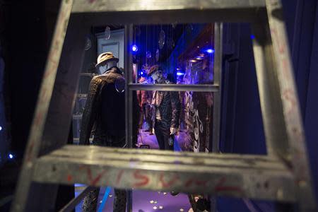 A ladder frames a window display advertising men's fashion and decorated with holiday ornaments inside the Saks Fifth Avenue store in New York, during preparations for the scheduled unveiling of the store's holiday windows, November 14, 2013. REUTERS/Lucas Jackson