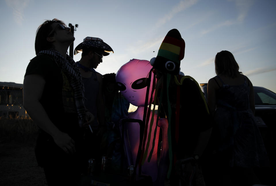 People stand around an inflatable alien at an entrance to the Nevada Test and Training Range near Area 51, Friday, Sept. 20, 2019, near Rachel, Nev. People came to visit the gate inspired by the "Storm Area 51" internet hoax. (AP Photo/John Locher)