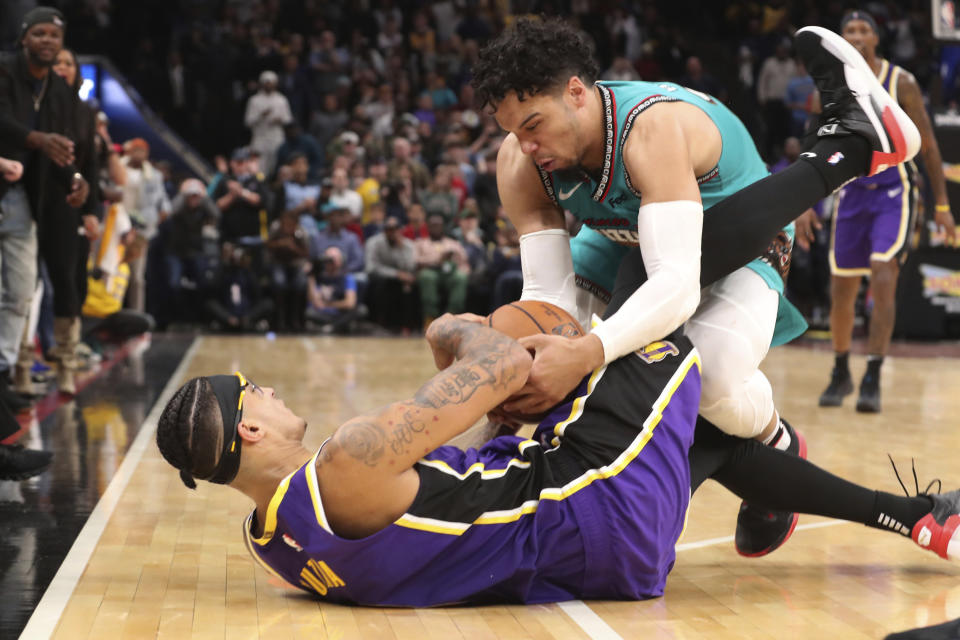 Memphis Grizzlies' Dillon Brooks (24) and Los Angeles Lakers' Kyle Kuzma (0) battle for the ball in the second half of an NBA basketball game Saturday, Nov. 23, 2019, in Memphis, Tenn. (AP Photo/Karen Pulfer Focht)