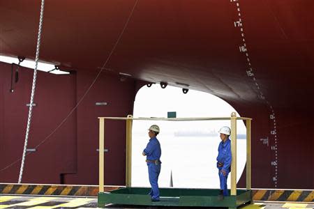 Workers stand in front of a 380,000 DWT class Very Large Ore Carrier (VLOC) during the naming ceremony of two Valemax ships built by Rongsheng Heavy Industries in Nantong, Jiangsu province, in this May 21, 2012 file photo. REUTERS/Aly Song/Files
