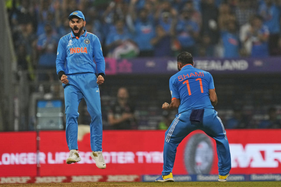 India's Mohammed Shami, right, celebrates with teammate Virat Kohli the wicket of New Zealand's Rachin Ravindra during the ICC Men's Cricket World Cup first semifinal match between India and New Zealand in Mumbai, India, Wednesday, Nov. 15, 2023. (AP Photo/Rajanish Kakade)