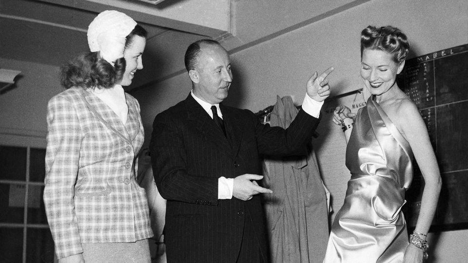 Dior is seen here in his fashion studio making adjustments to a fitted model. – AFP/Getty Images