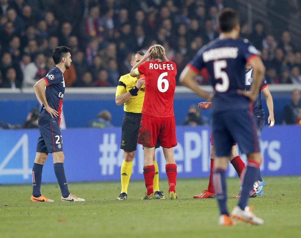 Leverkusen's Simon Rolfes holds his head as gets the red card from referee Ivan Bebek of Croatia during a Champions League last 16 second leg soccer match between Paris Saint Germain against Bayer Leverkusen at Parc des Princes stadium in Paris, Wednesday, March 12, 2014. (AP Photo/Michel Euler)