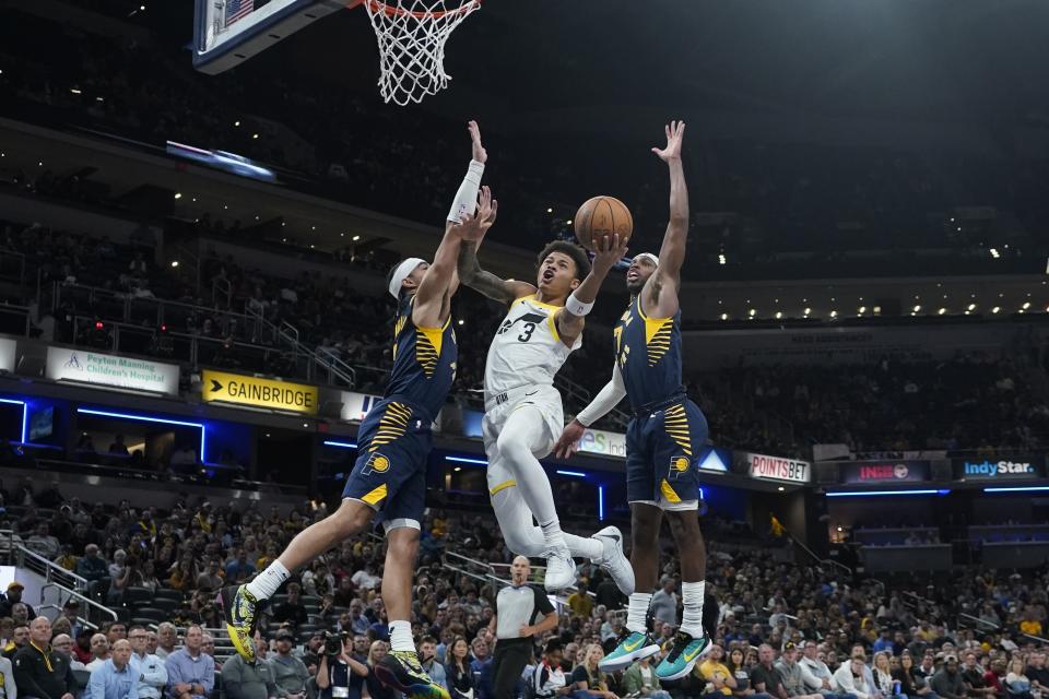 Utah Jazz's Keyonte George (3) shoots against Indiana Pacers' Andrew Nembhard, left, and Buddy Hield (7) during the second half of an NBA basketball game, Wednesday, Nov. 8, 2023, in Indianapolis. (AP Photo/Darron Cummings)