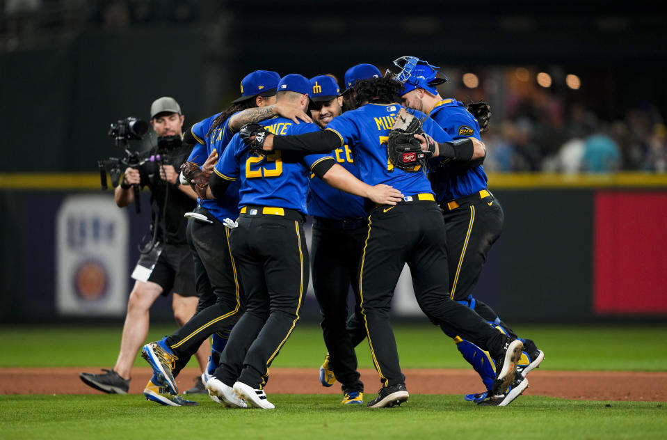 Seattle Mariners, including first baseman Ty France (23), third baseman Eugenio Suárez, center facing, and relief pitcher Andres Munoz (75) dance after the team's win over the Kansas City Royals in a baseball game Friday, Aug. 25, 2023, in Seattle. (AP Photo/Lindsey Wasson)