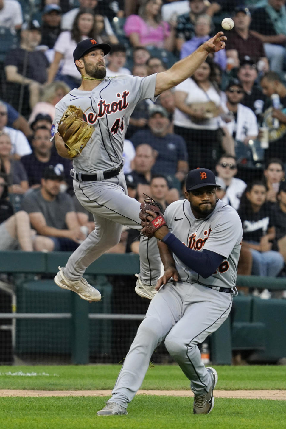 Detroit Tigers starting pitcher Daniel Norris throws to first base as third baseman Jeimer Candelario ducks, on a single by Chicago White Sox's Eloy Jimenez during the fourth inning of a baseball game in Chicago, Friday, Aug. 12, 2022. (AP Photo/Nam Y. Huh)