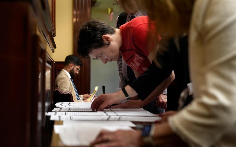 Shana Crandell, Community Organizer at Reclaim RI signs up to testify during a Senate hearing as landlords and tenants face off over renter-protection bills at the State House on Thursday night.