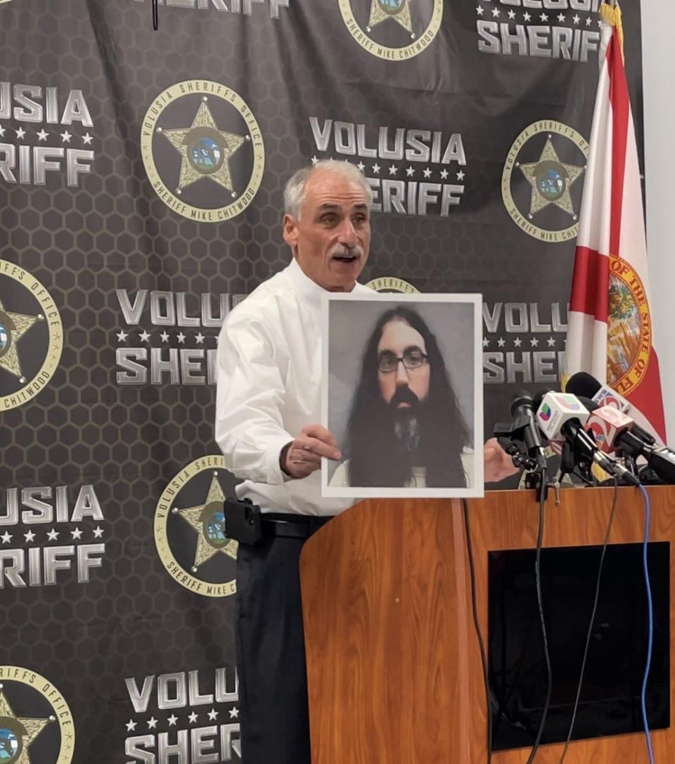 Volusia County Sheriff Mike Chitwood holds up the photo of Richard Golden, a New Jersey man arrested for posting death threats in a hate group chatroom to the sheriff. In a press conference on Tuesday, Chitwood spoke of how Golden was tracked down.