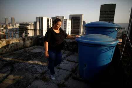 Yudith Contreras, a 49-year-old lawyer, who lives on the 9th floor, stands next to her water tanks on the roof her apartment block in downtown Caracas, Venezuela, March 18, 2019. Contreras said her family recycles the water by using it to flush the toilet. In her kitchen and bathroom, she keeps containers of water, which she carries up the nine floors to her apartment, a few blocks from the presidential Miraflores Palace. "You have to save water because we don't know how long this situation will go on for," she said. REUTERS/Carlos Garcia Rawlins