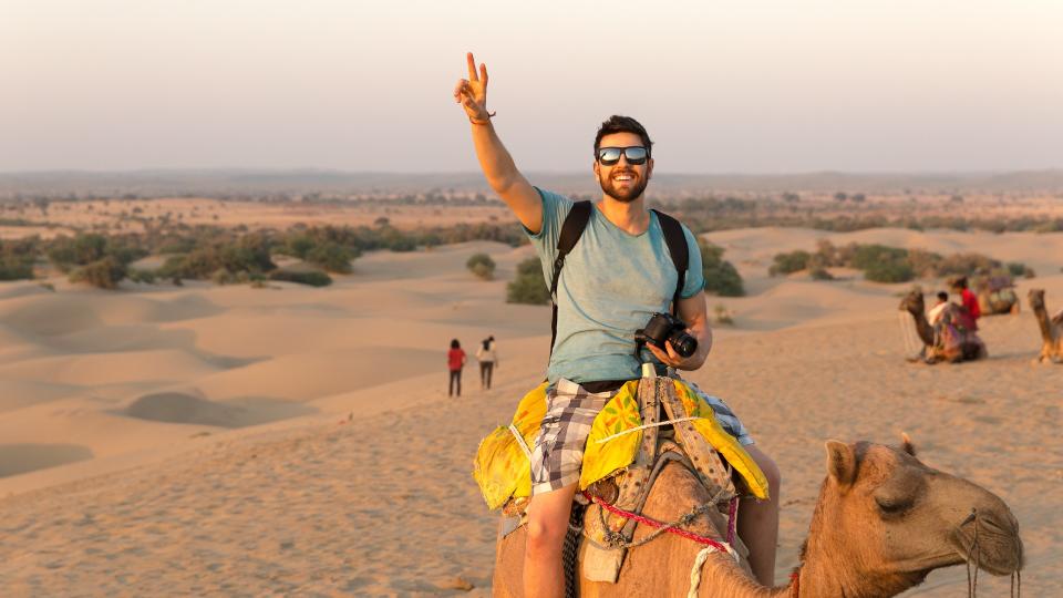 Tourist riding camel in Desert.