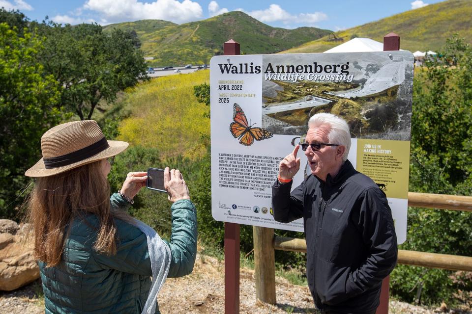 Steve Winter in front of an artists rendering of the Wallis Annenberg Wildlife Crossing
