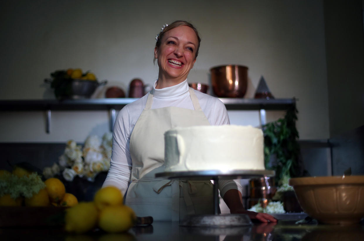 Owner of Violet Bakery in Hackney, east London, Claire Ptak poses for a portrait with a tier of the wedding cake of Britain's Prince Harry and US actress Meghan Markle in the kitchens of Buckingham Palace in London, on May 17, 2018. - Britain's Prince Harry and US actress Meghan Markle will marry on May 19 at St George's Chapel in Windsor Castle. (Photo by HANNAH MCKAY / POOL / AFP)        (Photo credit should read HANNAH MCKAY/AFP via Getty Images)