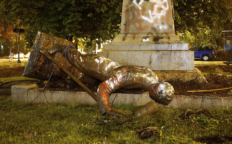 A statue from the Richmond Howitzers Monument in Richmond, Va., lies after being toppled Tuesday night, June 16, 2020, in Richmond, Va. The monument was erected in 1892 to commemorate a Richmond Civil War artillery unit, (Alexa Welch Edlund/Richmond Times-Dispatch via AP)