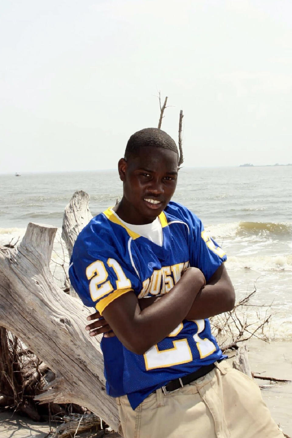 In this 2012 photo provided by Yolanda Richardson, of FuzzyRabbit Fotos, Ahmaud Arbery poses for a senior photo on St. Andrews Beach, Jekyll Island, Ga. Arbery was killed Feb. 23, 2020, after a pursuit by a white father and son who armed themselves and gave chase after seeing the 25-year-old black man running in their subdivision. (Yolanda Richardson/FuzzyRabbit Fotos via AP)