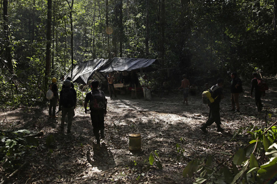 Tenetehara Indigenous men from the Ka'Azar, or Forest Owners, surround a camp of illegal loggers they discovered while patrolling their lands on the Alto Rio Guama reserve in Para state, near the city of Paragominas, Brazil, Tuesday, Sept. 8, 2020. Three Tenetehara Indigenous villages are patrolling to guard against illegal logging, gold mining, ranching, and farming as increasing encroachment and lax government enforcement during COVID-19 have forced the tribe to take matters into their own hands. (AP Photo/Eraldo Peres)