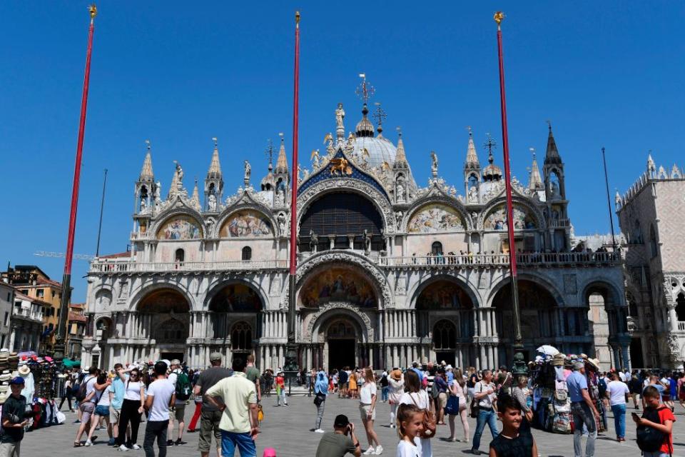 A picture taken in Venice on June 8, 2019 shows tourists taking pictures at the San Marco Basilica". (Photo by Miguel MEDINA/Getty Images/AFP)