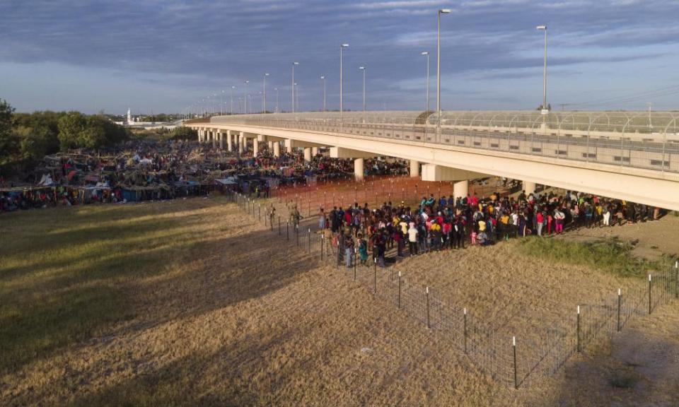 Migrants wait to get on to buses near the Rio Grande.