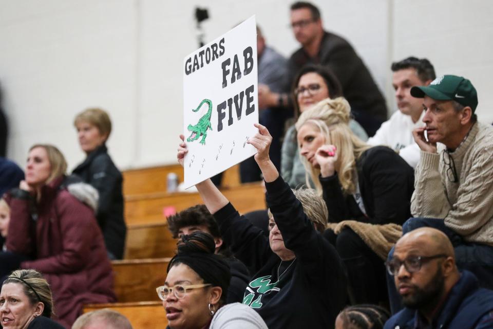 Janet Binder, grandmother of Ypsilanti Arbor Prep player Eliza Bush holds up a sign that says Gators Fab Five during the second half of Arbor Prep's 50-42 win in the MHSAA Division 3 regional semifinal at Concord High School on Tuesday, March 7, 2023.