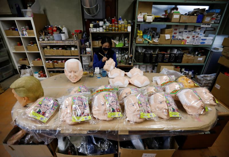 A worker of Ogawa Studios, a mask and toy making company, gives the final touches to a mask depicting U.S. President-elect Joe Biden after he was called winner of the presidential election, at its studio in Saitama, Japan