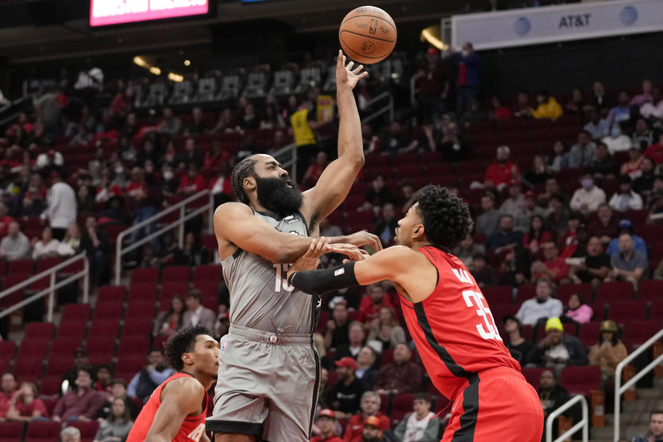 Brooklyn Nets guard James Harden, left, passes as Houston Rockets center Christian Wood defends during the first half of an NBA basketball game, Wednesday, Dec. 8, 2021, in Houston. (AP Photo/Eric Christian Smith)