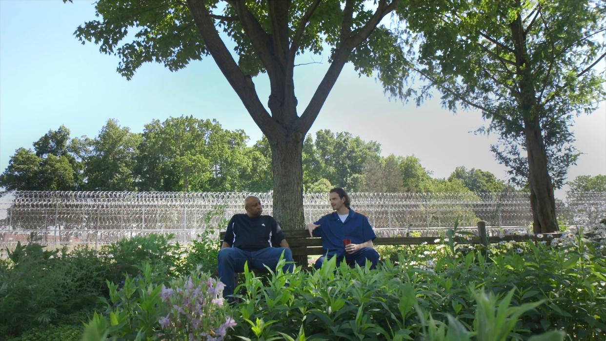 Chef Jimmy Lee Hill (left) talks with Bradley Leonard about the hardships of incarceration while sitting in the garden at Lakeland Correctional Facility in Coldwater, Mich. Chef Hill runs a highly regarded culinary training program that gives incarcerated men new skills and new hope. The program, Chef Hill and Bradley Leonard are part of the feature-length documentary film Coldwater Kitchen, produced by the Detroit Free Press. Photo Credit: Brian Kaufman