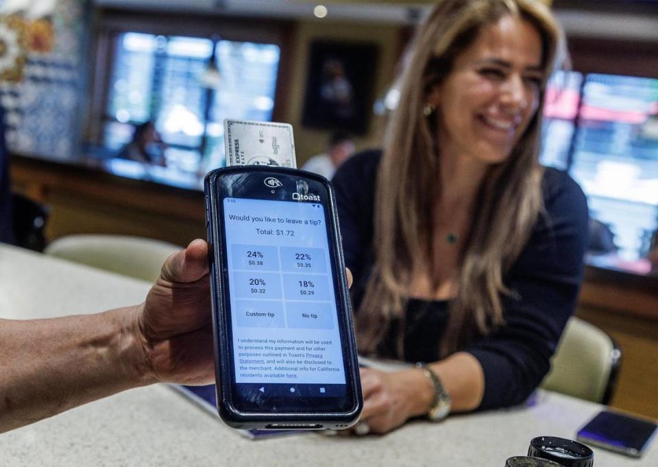 Mabel De Beunza gets ready to pay and tip the waiter at the Latin Cafe 2000, located at 2000, 875 NW 42nd Ave. in Miami, on Friday September 22, 2023. Pedro Portal/pportal@miamiherald.com