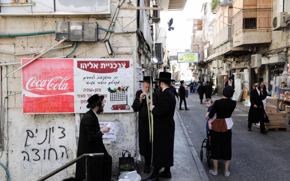 Ultra-Orthodox Jewish men carry Lulav or Palm branches, used during the celebration of Sukkot, the Feast of the Tabernacles, in the Ultra-Orthodox neighborhood of Mea Shearim - Abit Sultan/ EPA