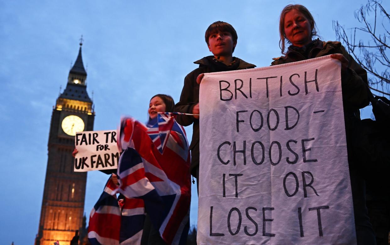 Crowds of people hold signs along the roadside