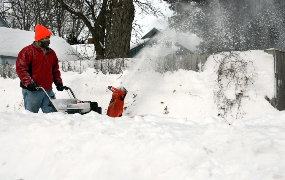Mike Neff uses a snow blower to clear the sidewalk at his house on Cherry St. in Oconomowoc on February 2, 2011. A winter storm brought blizzard conditions and a foot of snow in some areas.