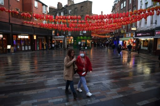 A visitor wears a face mask as she walks through London's Chinatown district