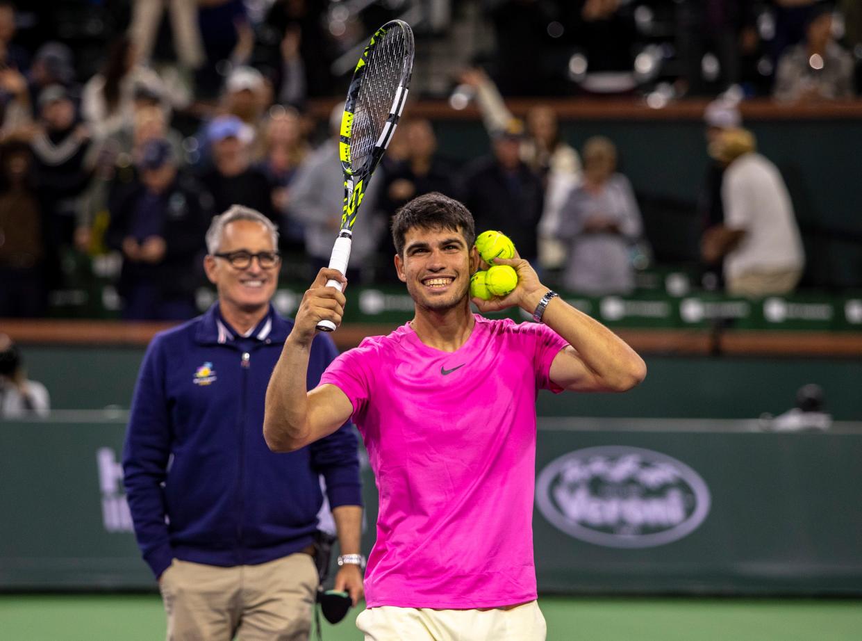 Carlos Alcaraz of Spain gestures for fans to get louder before hitting autographed tennis balls into the crowd for fans after defeating Thanasi Kokkinakis of Australia during their second-round match of the BNP Paribas Open at the Indian Wells Tennis Garden in Indian Wells, Calif., Saturday, March 11, 2023. 