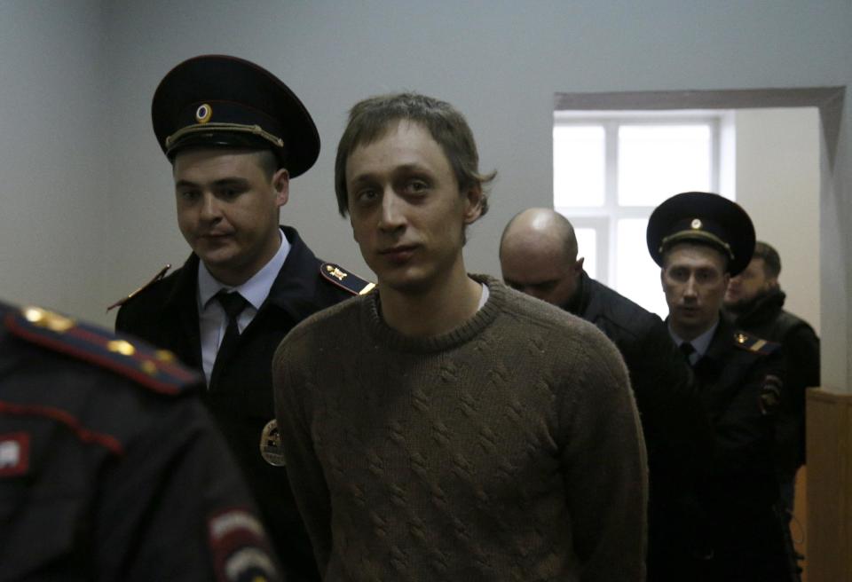 Pavel Dmitrichenko is excorted to a court room on Tuesday, Oct. 22, 103. Bolshoi dancer Dmitrichenko goes on trial on Tuesday, on charges of organizing an acid attack against the ballet's artistic director, Sergei Filin. (AP Photo/Alexander Zemlianichenko)