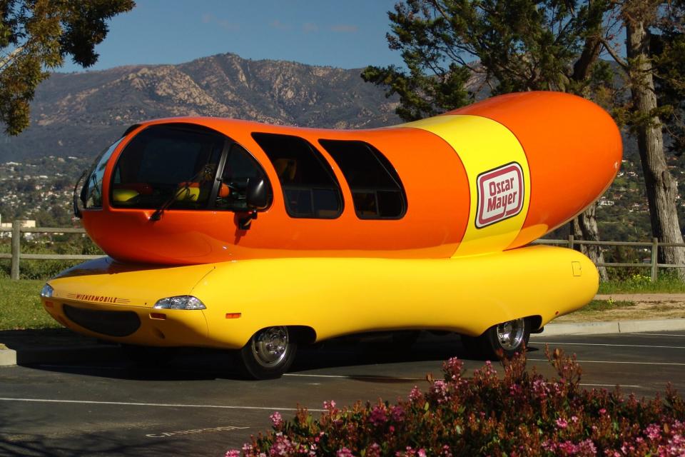 The Oscar Mayer Wienermobile in front of a mountain background