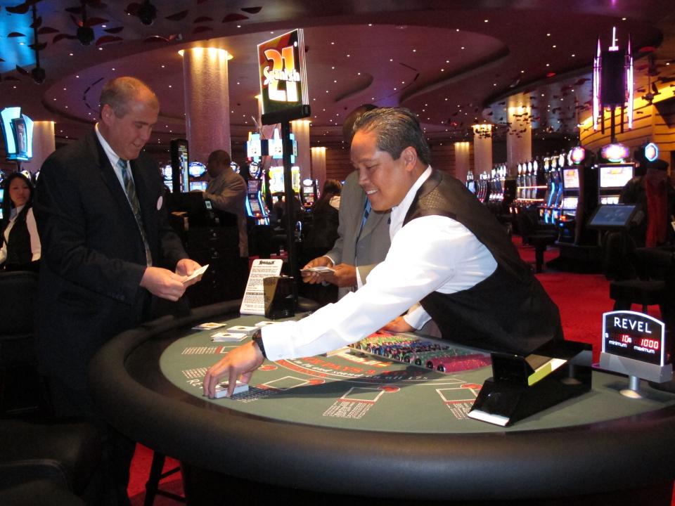 Dealer Elbert Taclan, right, prepares a card game moments after the $2.4 billion Revel casino resort opened in Atlantic City, N.J., Monday, April 2, 2012. John Koryto, left, was watching him prepare for the first customers to arrive at the table. (AP Photo/Wayne Parry)