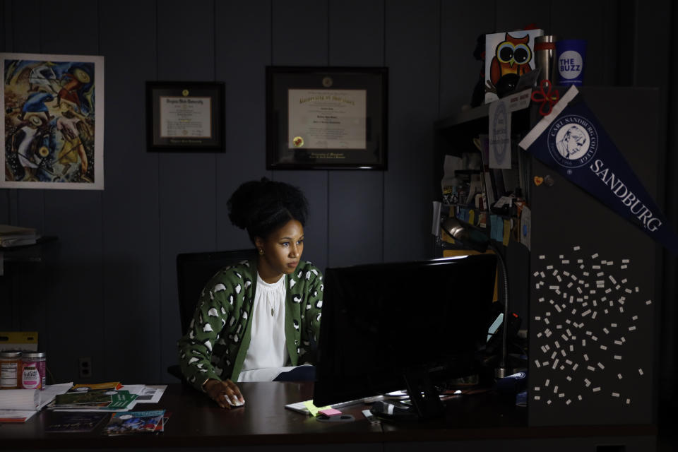 Brittany Grimes, president of the local NAACP, works in her Carl Sandburg College office Thursday, June 17, 2021, in Galesburg, Ill. Grimes, pressed Mayor John Pritchard with a report that most of Galesburg's 14-percent Black population, thousands of citizens, were living in poverty and that local Black residents were being under tested for coronavirus and victims of other public inequities. Pritchard fought a resolution sought by the NAACP to acknowledge "institutionalized racism" in policing, hiring, public health and other facets of community life. (AP Photo/Shafkat Anowar)