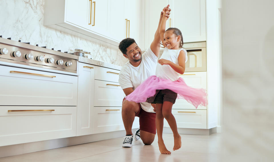 father and daughter dancing in their kitchen