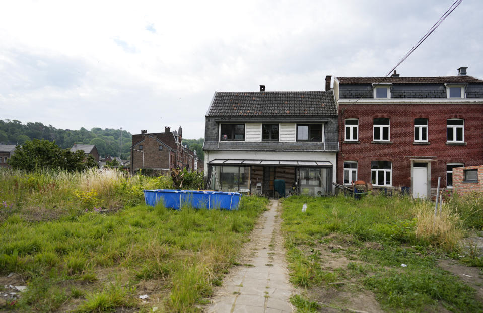 A swimming pool and a cement mixer sit on an overgrown lawn in front of a damaged house in Nessonvaux, Belgium, on Thursday, July 14, 2022. Commemorations were held on Thursday to pay homage to the victims of catastrophic flooding in several provinces of Belgium after torrential rains fell in the region one year ago. (AP Photo/Virginia Mayo)