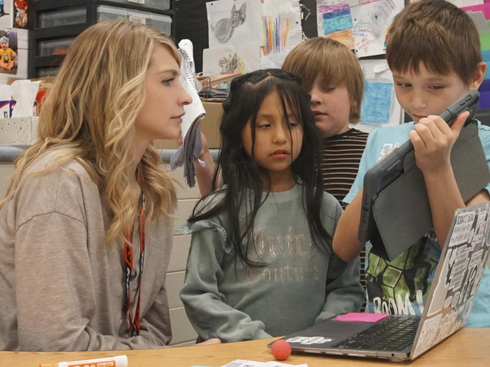 Ashlie Monroe, a second grade teacher at Endeavor Elementary, helps her students on Feb. 29, 2024, in Nampa, Idaho. Monroe has two children enrolled in the school's onsite daycare. (Carly Flandro/Idaho Education News via AP)