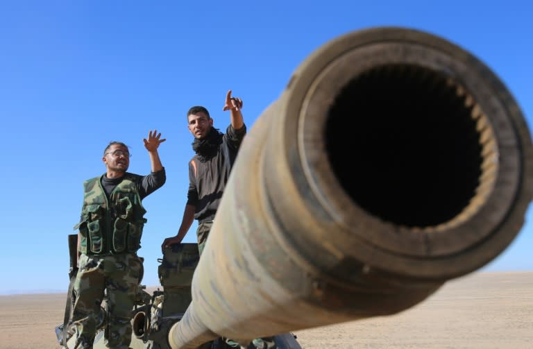 Syrian pro-government forces stand on a tank they reportedly captured overlooking the town of Mahin in Homs province on November 14, 2015