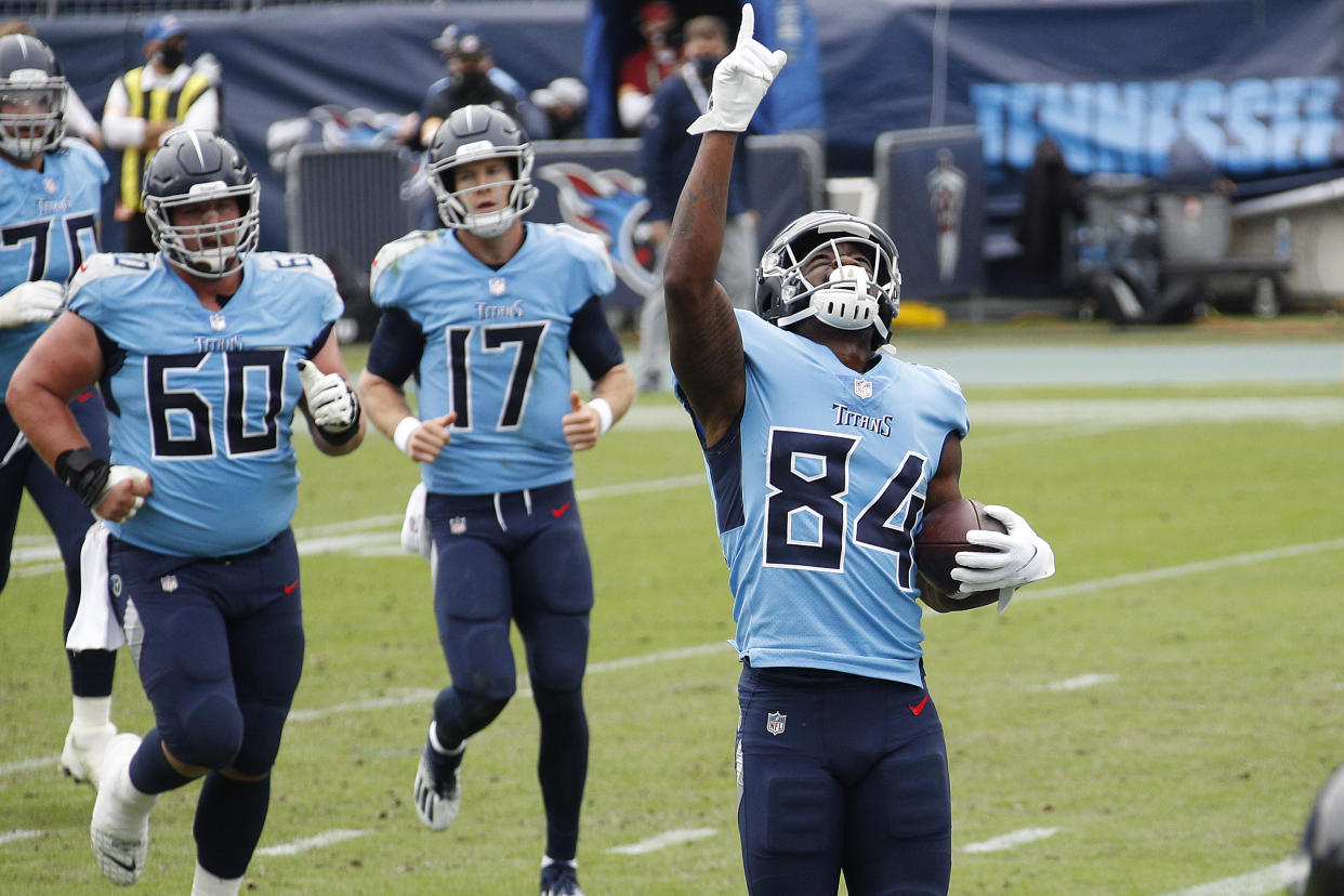 Corey Davis points to the sky, football in hand. 