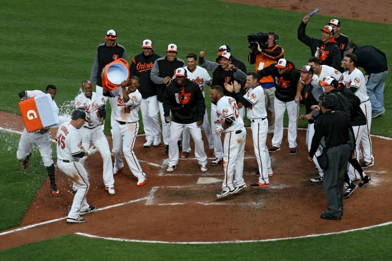 Mark Trumbo (No. 45) of the Baltimore Orioles is greeted at home plate after hitting a walk-off home run against the Toronto Blue Jays during the eleventh inning in their opening day game, at Oriole Park in Baltimore, Maryland, on April 3, 2017