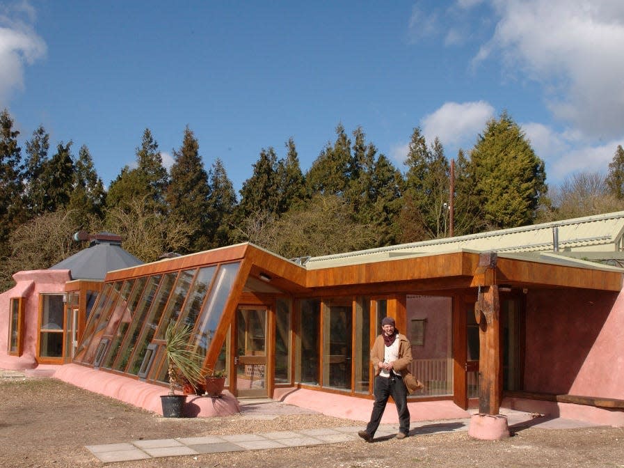 earthship in brighton with man standing in front of it