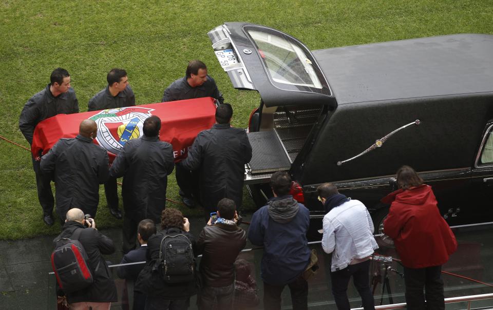 Men prepare to place the coffin of Eusebio into a hearse at Luz stadium in Lisbon