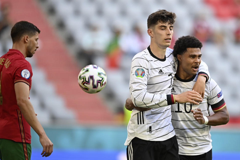 Germany's Kai Havertz celebrates with Serge Gnabry, right, after scoring his side's third goal during the Euro 2020 soccer championship group F match between Portugal and Germany at the Football Arena stadium in Munich, Germany, Saturday, June 19, 2021. (Philipp Guelland/Pool via AP)