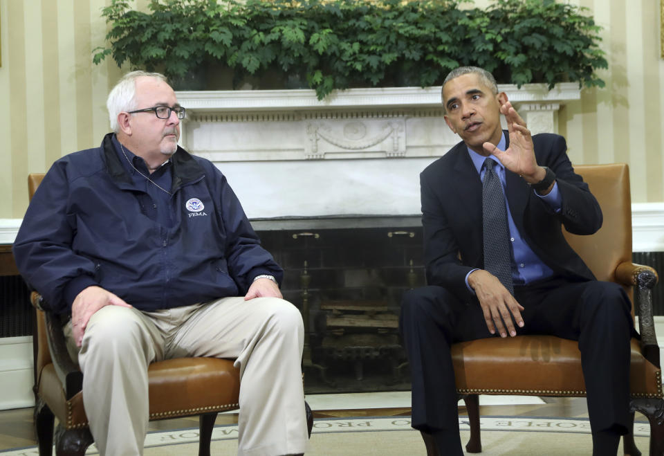 FILE - In this Oct. 7, 2016, file photo, President Barack Obama with FEMA Administrator Craig Fugate, speaks to reporters in the Oval Office of the White House in Washington. In the time of coronavirus, America turns its worried eyes to Dr. Fauci and other experts. That's a big shift after decades of the public and its leaders downplaying the advice from scientists and other experts on everything from climate change to disaster planning. But things are changing as the COVID-19 pandemic worsens, Fugate said. (AP Photo/Manuel Balce Ceneta, File)