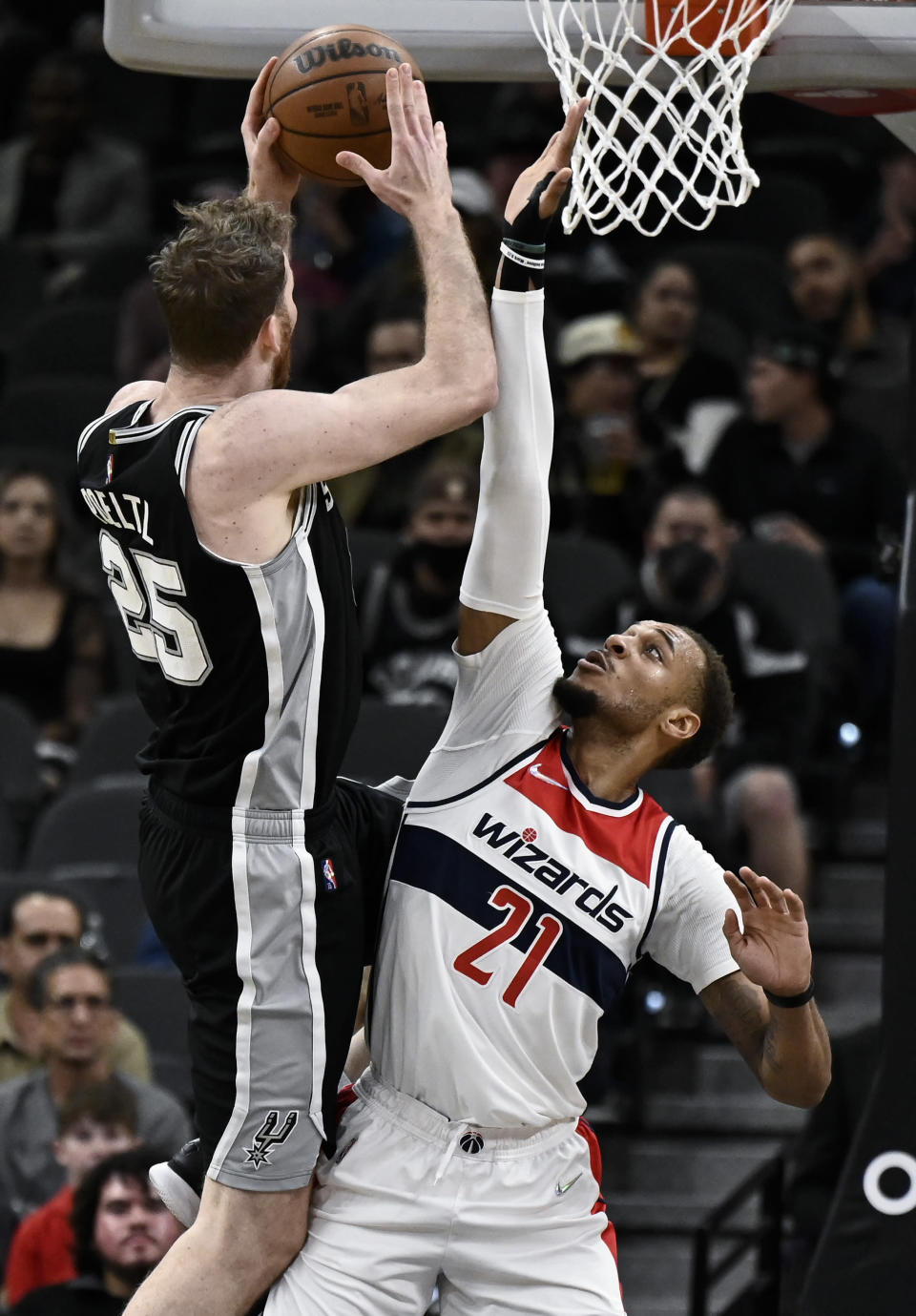 Washington Wizards' Daniel Gafford (21) attempts to block a shot by San Antonio Spurs' Jakob Poeltl during the first half of an NBA basketball game, Monday, Nov. 29, 2021, in San Antonio. (AP Photo/Darren Abate)